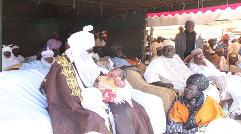 The Emir of Kano Mallam Muhammad Sanusi II holding one of the children whose mothers accessed ANC services during pregnancy