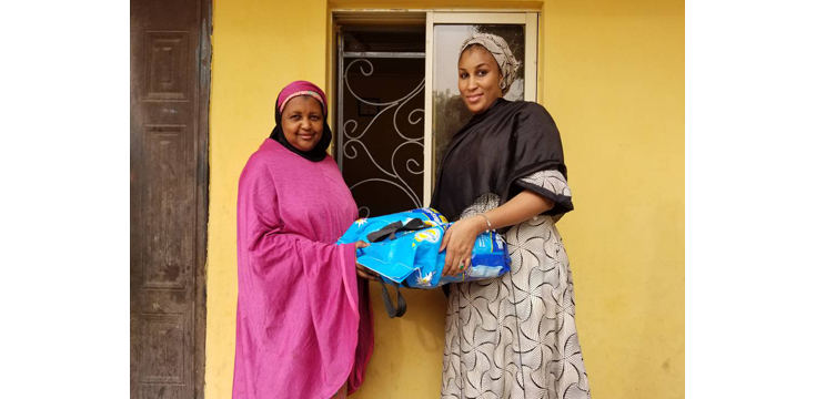 Alawiyya Garba (left) receiving a pack of mosquito repellent coil from Halima Halilu, deputy curator